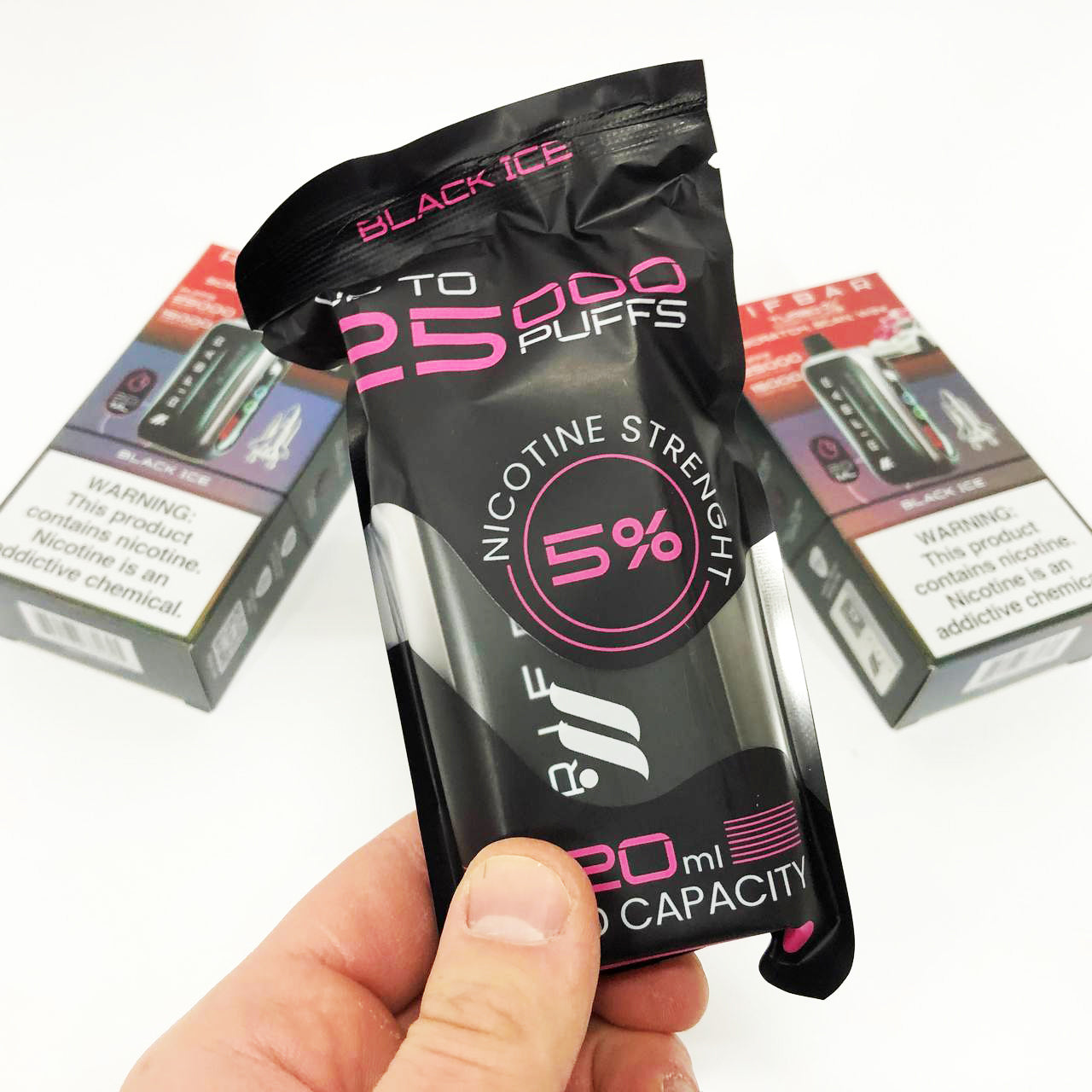 Hand holding a nicotine strength 5% vape device packaging with 'Black Ice' branding.